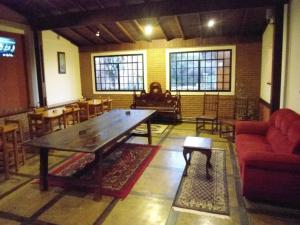 波苏斯-迪卡尔达斯Pousada Danza - Centro的客厅配有木桌和椅子