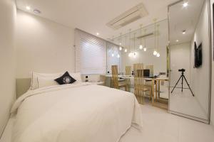 首尔库利南杰奥德酒店的一间带白色床的卧室和一间厨房