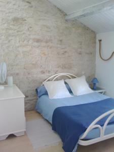 Chabournayla Rosaliere的一间卧室设有蓝色的床和石墙