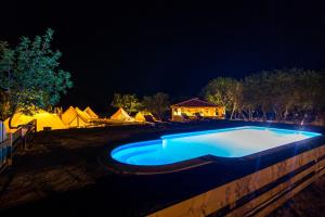 Gornji HumacBoutique Camping Nono Ban的夜间游泳池,带帐篷