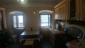 帕里斯特BellaVistaZmukic Guesthouse的厨房配有桌子和2扇窗户。