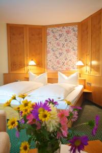 伊勒蒂森道韦勒之家酒店及餐厅的酒店客房的地板上设有两张带鲜花的床。