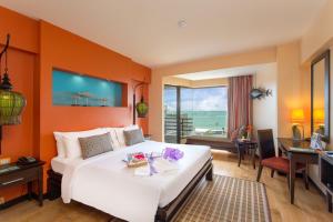 芭堤雅市中心The Bayview Hotel Pattaya的一间卧室配有一张带橙色墙壁的大床