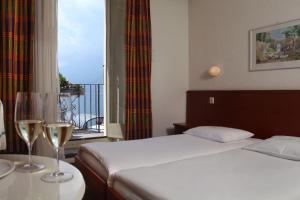 阿斯科纳阿斯科纳广场餐厅酒店 的酒店客房,配有床和两杯酒杯