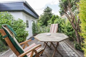 劳特尔巴赫Ferienwohnungen in ruhiger Ortsran的庭院配有两把椅子和一张木桌及椅子