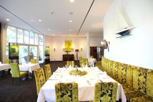 雷根斯堡雷根斯堡汉萨公寓酒店的用餐室配有白色的桌子和黄色的椅子