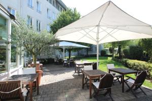 雷根斯堡雷根斯堡汉萨公寓酒店的一个带桌椅和遮阳伞的庭院