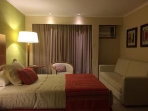 帕特拉德拉帕特拉帕索德拉帕特里亚康达多赌场酒店的酒店客房,配有床和沙发