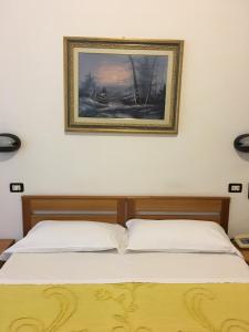 都灵多拉酒店的卧室内的两张床,墙上挂着一幅画