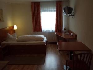 曼海姆爱尔派兹酒店的配有一张床、一张书桌和一扇窗户的酒店客房