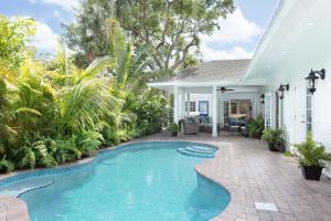 西棕榈滩Palm Beach Oasis 3bd 3ba Private Pool plus Parking的一座植物繁茂的房屋后院的游泳池