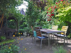 奈梅亨海特布劳乌尔早餐加卧室旅馆的花园里种满鲜花,配有桌椅
