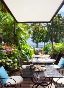 代森扎诺-德尔加达公园酒店的庭院设有桌椅和鲜花