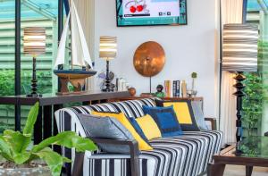 芭堤雅市中心Wave Hotel Pattaya的客厅配有条纹沙发和灯具