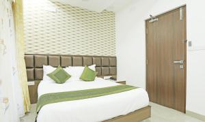 钦奈Treebo Trend Pechis Castle的一间卧室配有一张带绿色枕头的大床