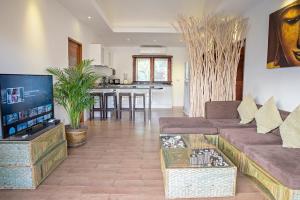 湄南海滩热带季节度假别墅的客厅配有沙发和桌子