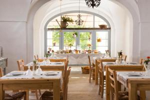 滨海波利尼亚诺Masseria Le Torri的带窗户的用餐室内设有带桌椅的用餐室
