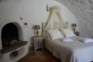 艾日维勒贝日里酒店的卧室配有白色的床和壁炉