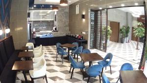 釜山Stanford Hotel Busan的餐厅设有木桌和蓝色椅子