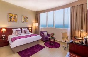 富查伊拉富查伊拉V酒店的一间卧室配有一张大床和紫色地毯。