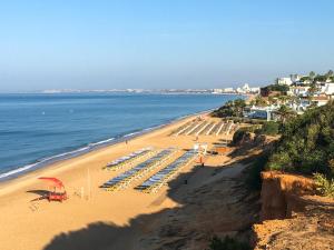 韦尔都勒博Casa das Flores的海滩上设有椅子和遮阳伞,还有大海