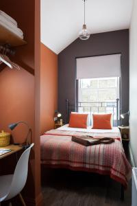 伦敦佩卡姆酒店的一间卧室配有一张带橙色墙壁和窗户的床
