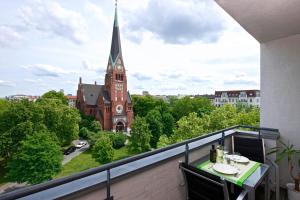 柏林Art'Appart Suiten - kontaktloser Check-In的阳台享有教堂和钟楼的景色