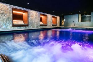 马尔格莱特德玛AQUA Hotel Silhouette & Spa - Adults Only的一座蓝色和紫色水的大型游泳池