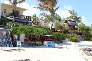 蓝海湾创尔特房檐宾馆的沙滩上的房子,沙滩上设有冲浪板