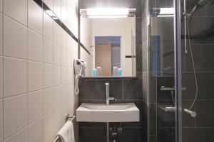 吕伐登巴斯通吕伐登酒店的一间带水槽和镜子的浴室