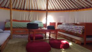 Saint-Florent-des-BoisAux Yourtes de La Fabrique的一间设有两张床的房间和一张帐篷内的桌子