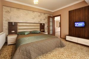 科贾埃利巴勒特之家公寓式酒店的一间卧室配有一张大床和一台平面电视