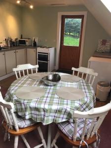 FinzeanWhitehill的厨房配有带四把椅子和一张桌子的桌子以及窗户。