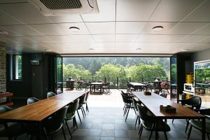 求礼郡CAMP Jirisan Parkview的餐厅设有桌椅和大窗户。
