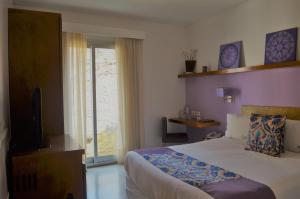 布宜诺斯艾利斯麦安酒店的一间卧室设有一张床、一台电视和一个窗口。