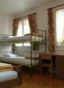 因特拉肯滑稽农场背包客旅馆的一间卧室配有两张双层床和椅子