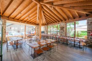 Robles de LacianaHotel Rural La Bolera的一间设有桌椅的餐厅,位于带窗户的房间内