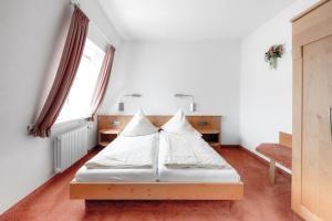 里格尔Gasthof - Hotel Kopf的一间卧室配有带白色床单和枕头的床。