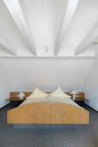 里格尔Gasthof - Hotel Kopf的卧室配有木床和白色墙壁