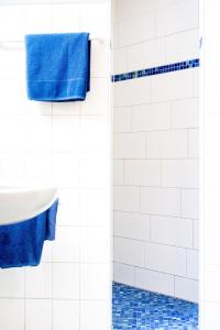 里格尔Gasthof - Hotel Kopf的一间带蓝色毛巾和淋浴的浴室