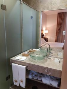 科英布拉壹贝爱瑞科酒店的浴室在带镜子的柜台上设有玻璃碗