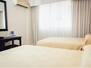 比亚埃尔莫萨比亚埃尔莫萨米拉弗洛雷斯酒店的酒店客房设有两张床和窗户。