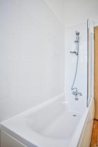 爱丁堡康慕莉班克公寓的浴室设有带淋浴的白色浴缸。
