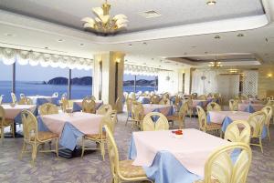 志布志市斯步赛瓦达凯库度假酒店的配有桌椅的宴会厅,享有海景
