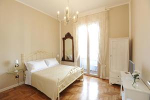 那不勒斯Residenza Borbonica的一间卧室配有一张床、镜子和窗户