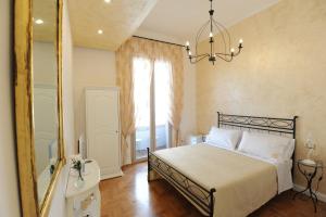 那不勒斯Residenza Borbonica的一间卧室配有一张带镜子和吊灯的床。