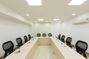 诺伊达GINGER Noida City Center的一间会议室,配有长桌子和椅子