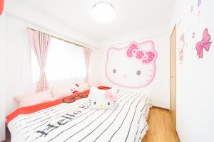 淡路NC03淡路中央公寓的一间卧室配有一张床和小猫床头