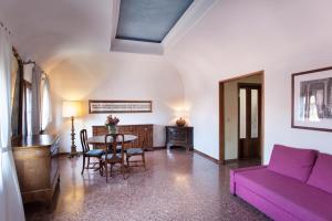 维琴察瓦尔马拉纳布拉加宫酒店的客厅配有紫色沙发和桌子