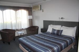 沃纳姆堡拉格伦汽车旅馆的酒店客房带一张床、一张桌子和椅子